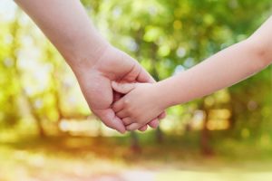 53911791 - fathers hand holding his little child in sunny day outdoor, united family and happy childhood concept, beautiful bokeh background